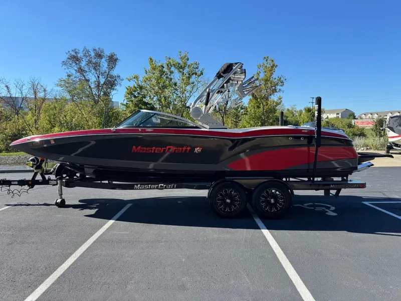 Slide: The Image of 2014 MasterCraft X46 boat on trailer, black and red design, parked outdoors. - 7