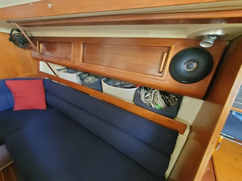 Slide: The Image of Interior of 1987 Pearson 31-2 sailboat with blue seating and wooden storage compartments. - 11