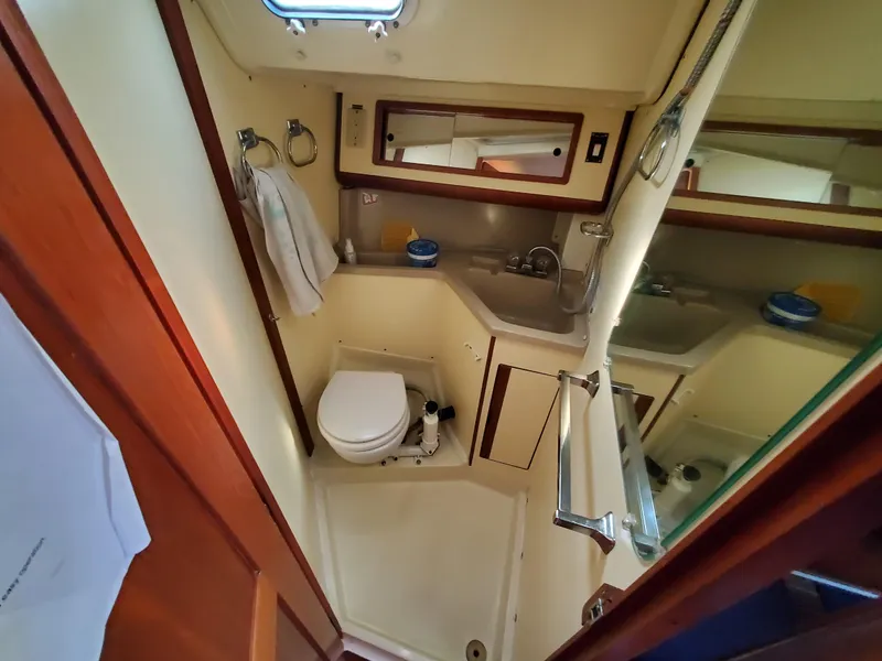 Slide: The Image of 1987 Pearson 31-2 yacht bathroom with sink, toilet, and mirror. - 14