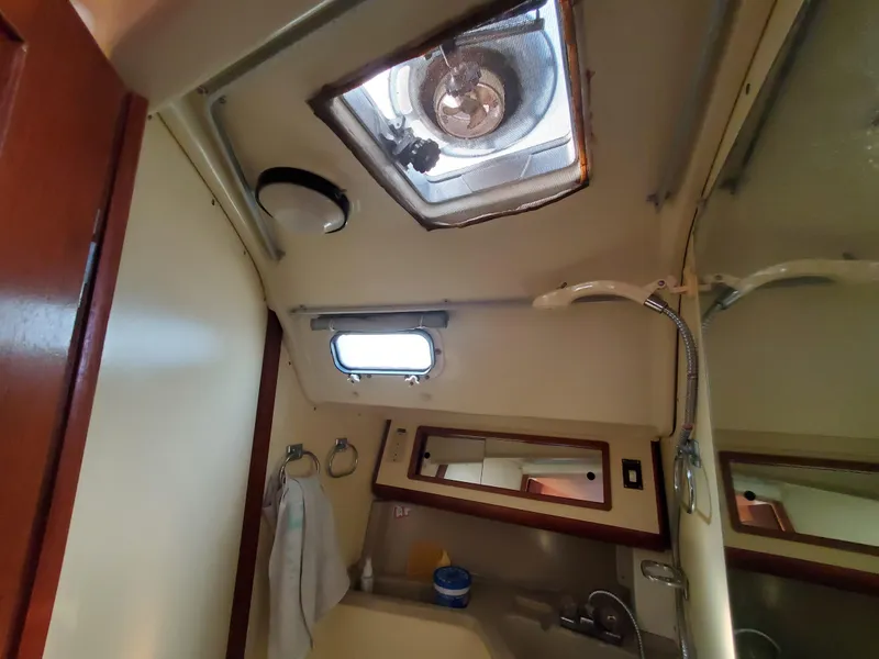 Slide: The Image of Interior of 1987 Pearson 31-2 sailboat bathroom with sink, mirror, and porthole. - 15