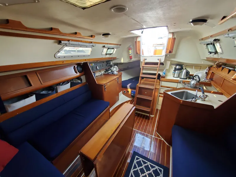Slide: The Image of Interior of 1987 Pearson 31-2 sailboat with wooden furnishings and blue seating. - 16
