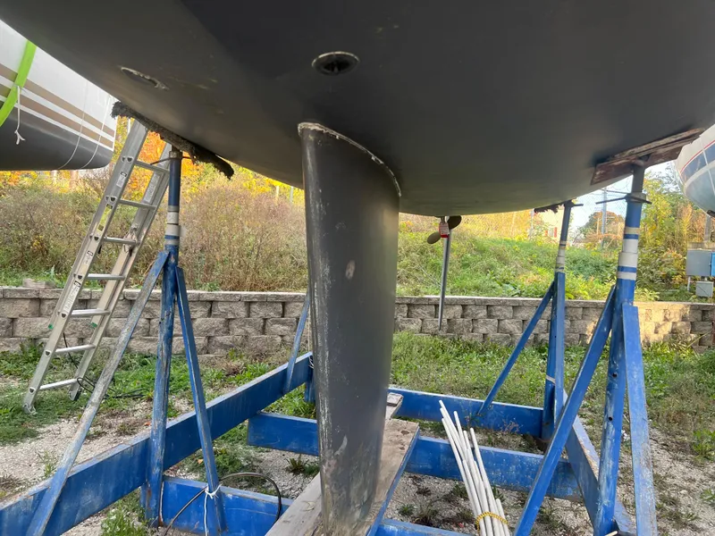 Slide: The Image of 1987 Pearson 31-2 sailboat on stands, keel view, outdoor setting. - 24