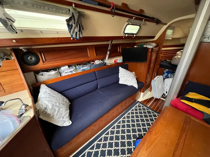 Slide: The Image of Interior of 1987 Pearson 31-2 sailboat with blue sofa and wooden accents. - 30