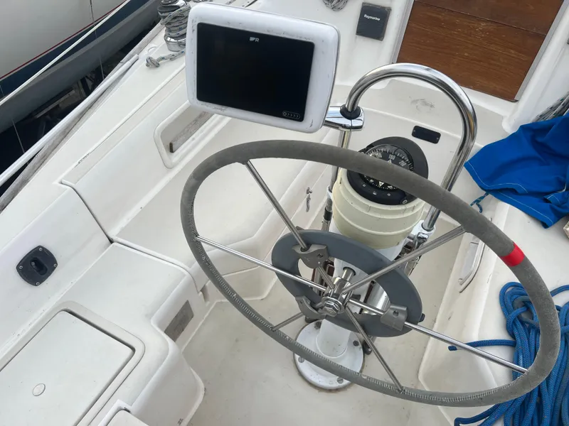 Slide: The Image of 1987 Pearson 31-2 sailboat cockpit with steering wheel and navigation equipment. - 6