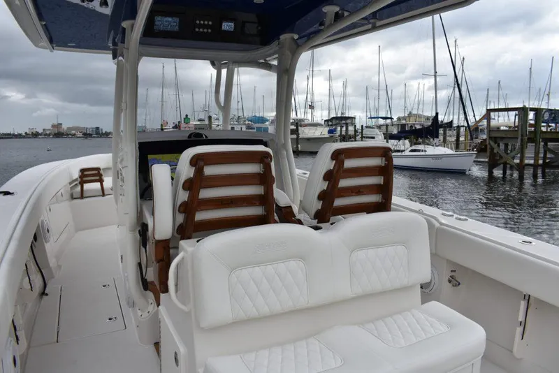 Slide: The Image of 2025 Jupiter 34 boat interior with white seating, docked at a marina. - 3