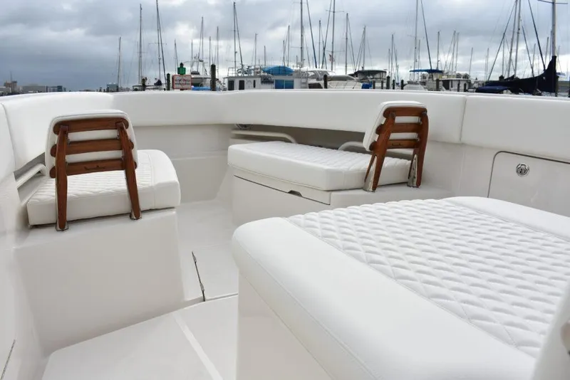 Slide: The Image of 2025 Jupiter 34 boat interior with cushioned seating at marina. - 5