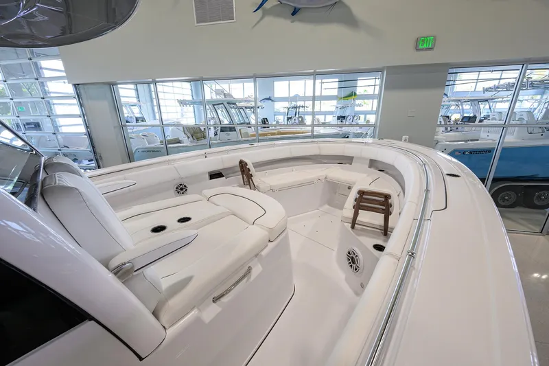 Slide: The Image of 2025 Sportsman Open 352 boat interior with white seating and modern design in showroom. - 18