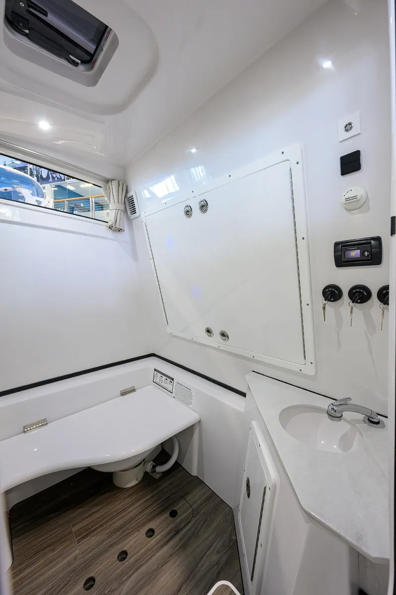 Slide: The Image of 2025 Sportsman Open 352 boat interior bathroom with modern fixtures and wood-style flooring. - 40