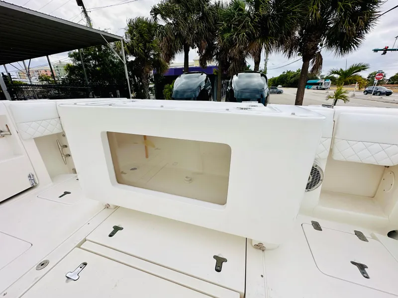 Slide: The Image of 2004 Intrepid 370 Open boat deck with storage compartment and palm trees in background. - 13