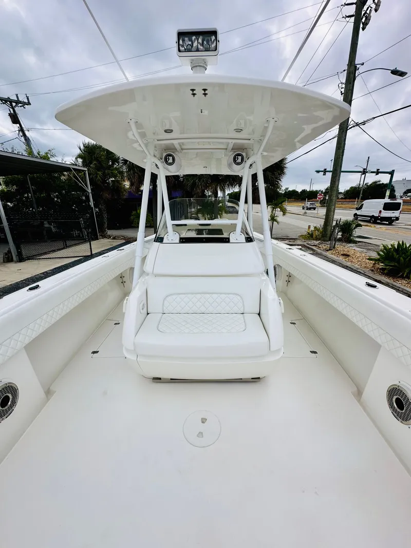 Slide: The Image of 2004 Intrepid 370 Open boat with spacious deck and seating, docked outdoors. - 29
