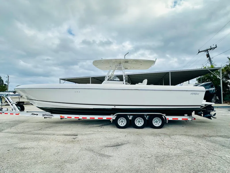 Slide: The Image of 2004 Intrepid 370 Open boat on trailer under cloudy sky. - 5