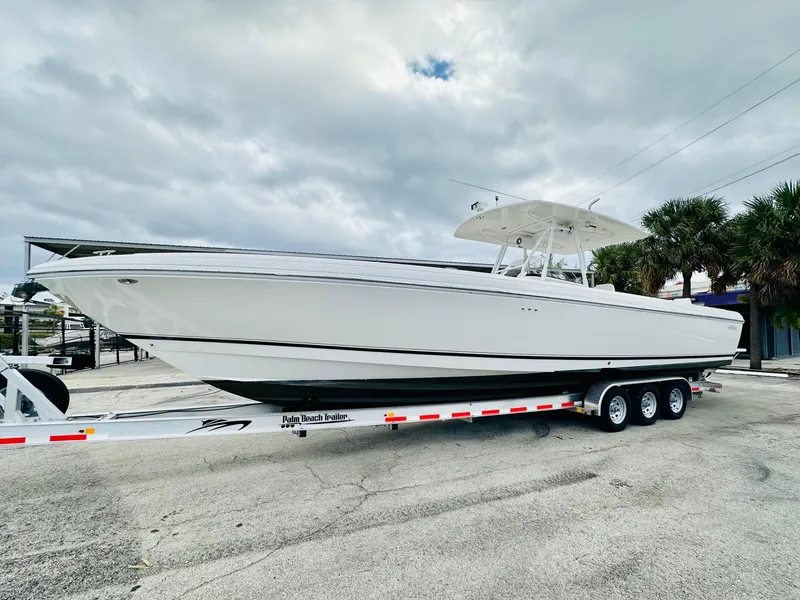 Slide: The Image of 2004 Intrepid 370 Open boat on trailer, parked outdoors under cloudy sky. - 6