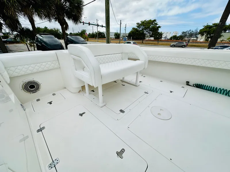 Slide: The Image of 2004 Intrepid 370 Open boat deck with white seating and storage compartments. - 8
