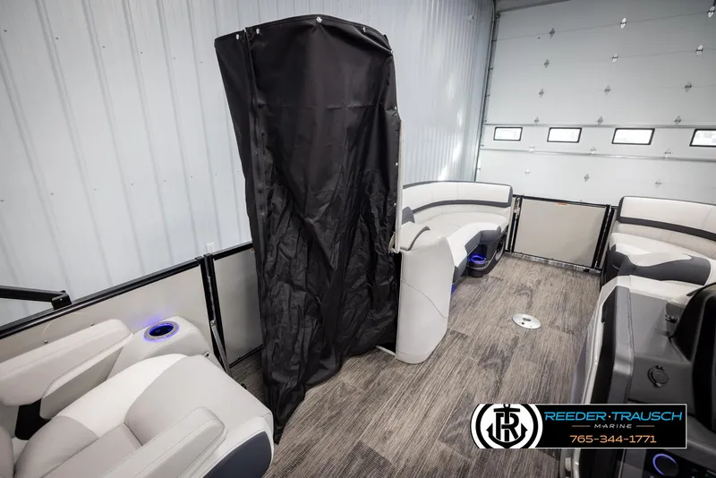 Slide: The Image of 2025 Avalon Catalina QL boat interior with seating and privacy curtain in a showroom. - 22