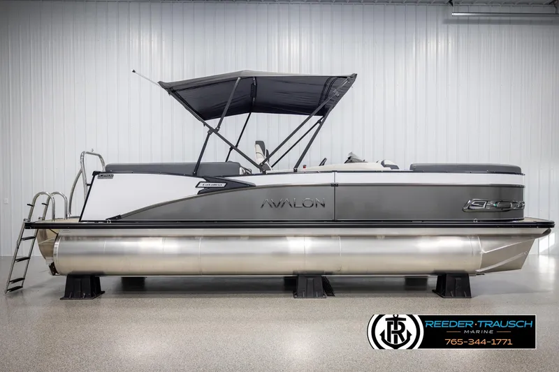Slide: The Image of 2025 Avalon Catalina QL pontoon boat in showroom with canopy and sleek design. - 5