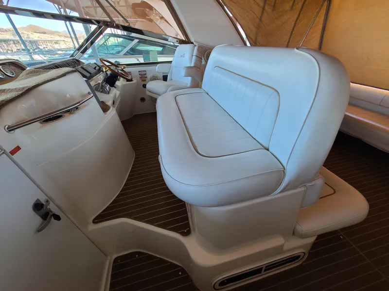 Slide: The Image of 1998 Sea Ray 400 Sundancer interior with white leather seating and helm. - 11