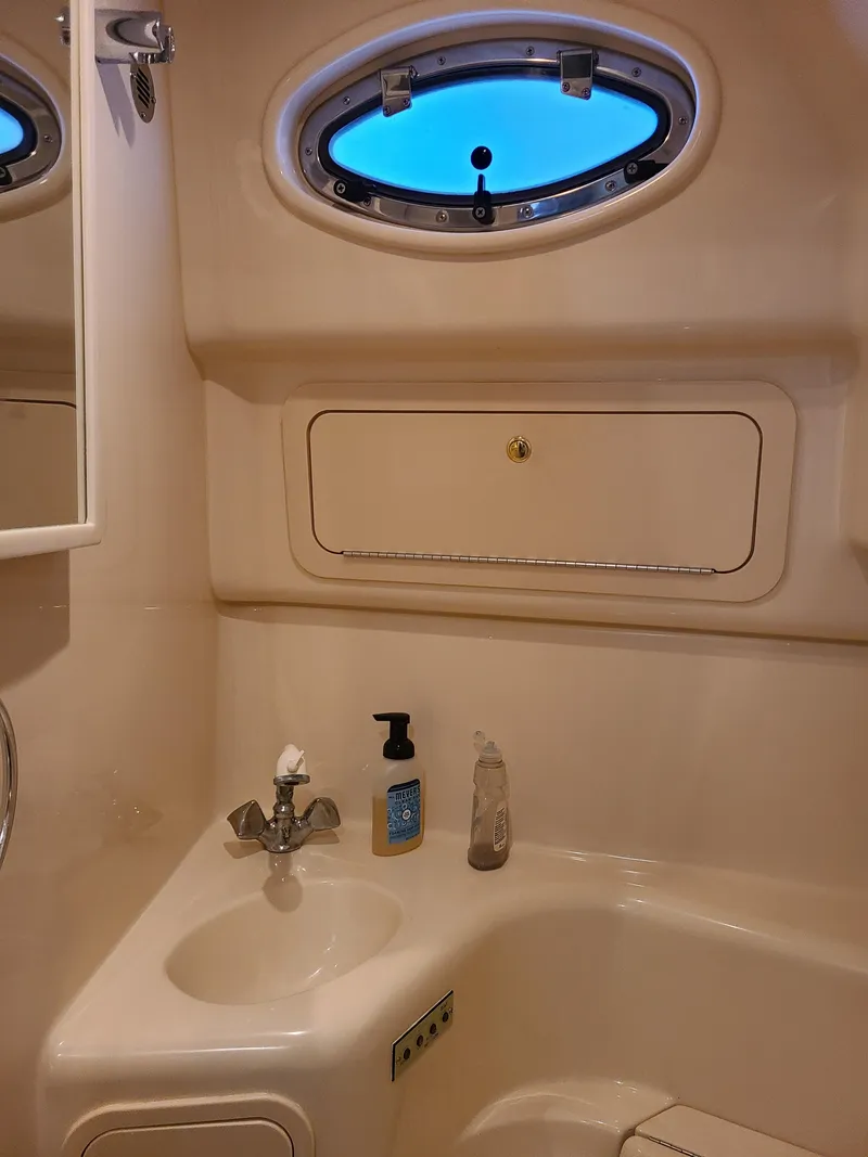 Slide: The Image of Bathroom interior of 1998 Sea Ray 400 Sundancer yacht with sink and porthole window. - 16