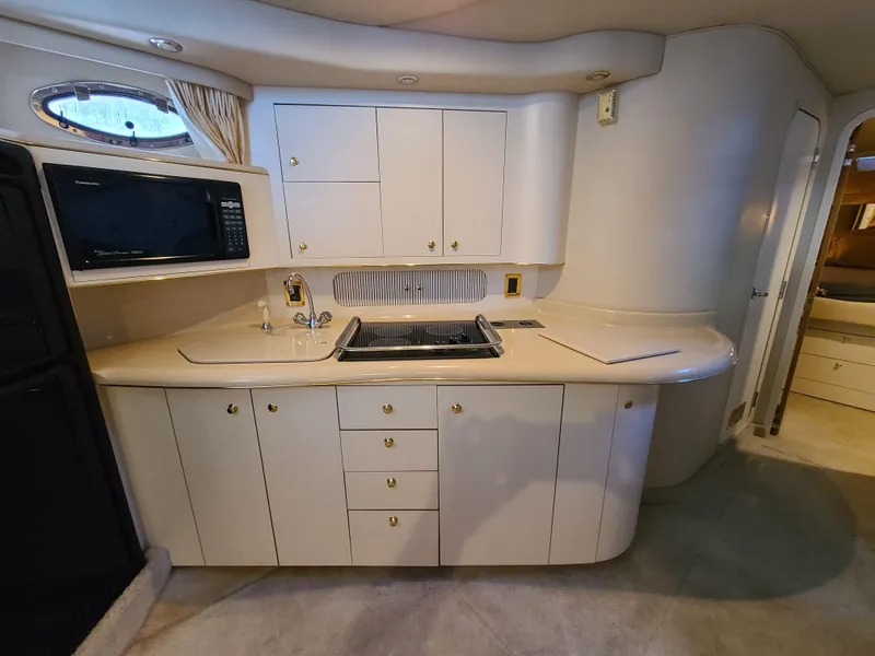 Slide: The Image of Interior of 1998 Sea Ray 400 Sundancer yacht kitchen with cabinets and appliances. - 17