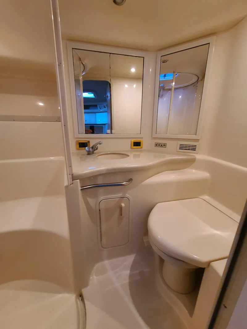 Slide: The Image of 1998 Sea Ray 400 Sundancer bathroom with modern fixtures and mirrored cabinets. - 21