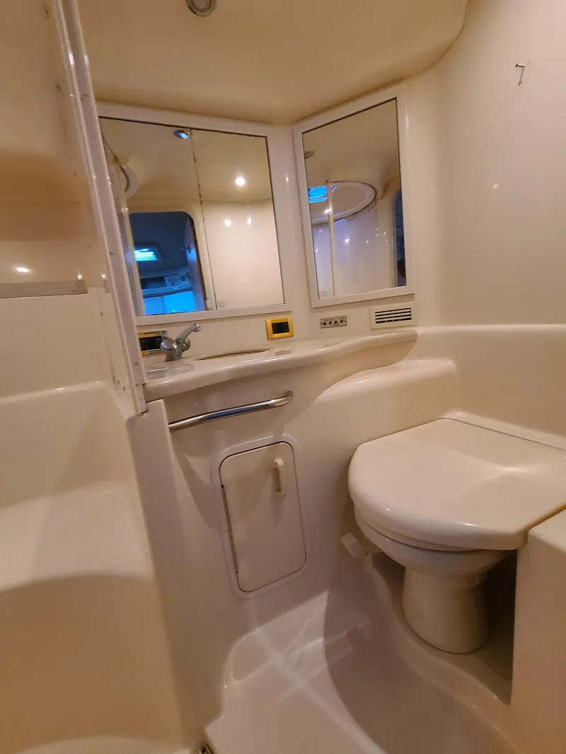 Slide: The Image of 1998 Sea Ray 400 Sundancer bathroom with modern fixtures and mirrored cabinets. - 23