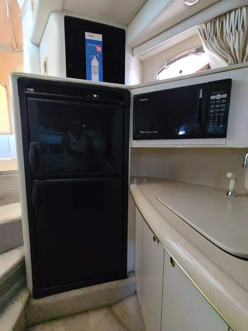 Slide: The Image of 1998 Sea Ray 400 Sundancer kitchen with fridge, microwave, and counter space. - 24