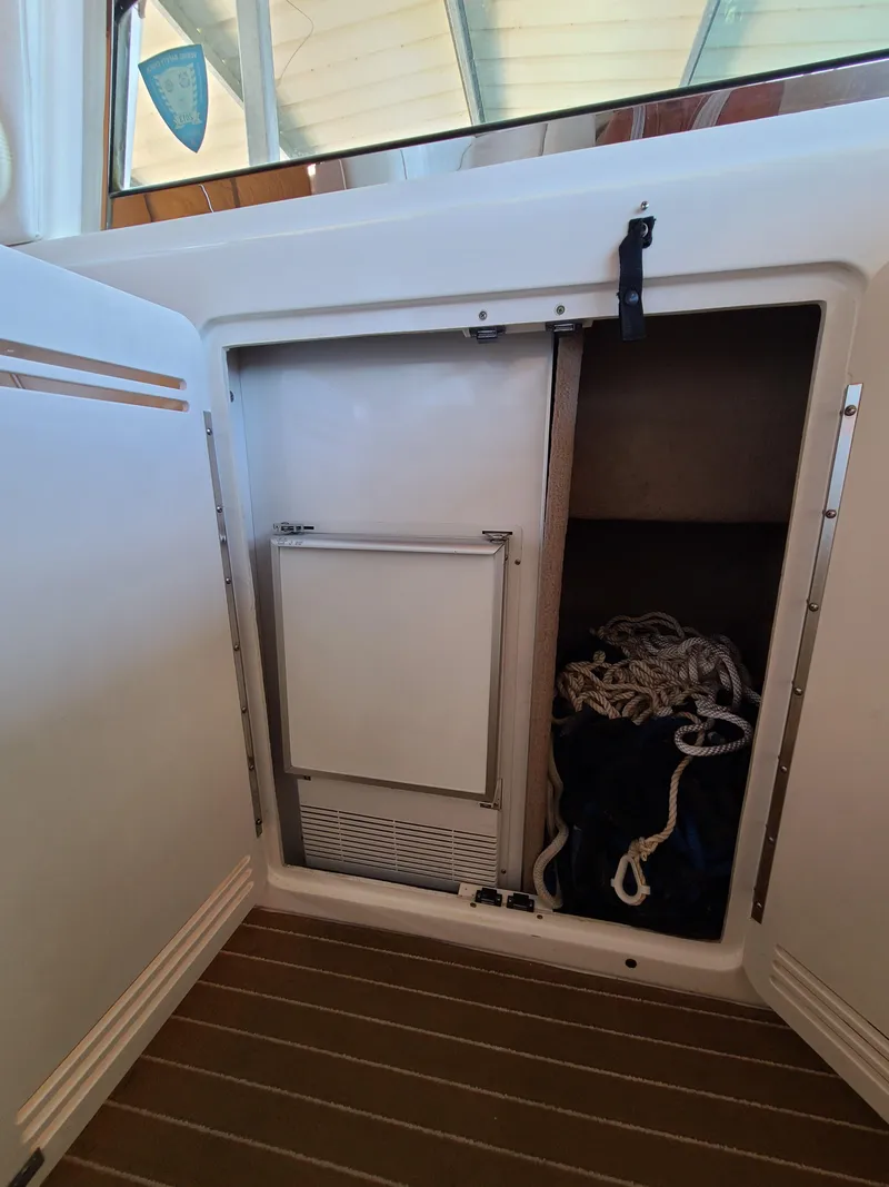 Slide: The Image of 1998 Sea Ray 400 Sundancer storage compartment with ropes and equipment. - 26