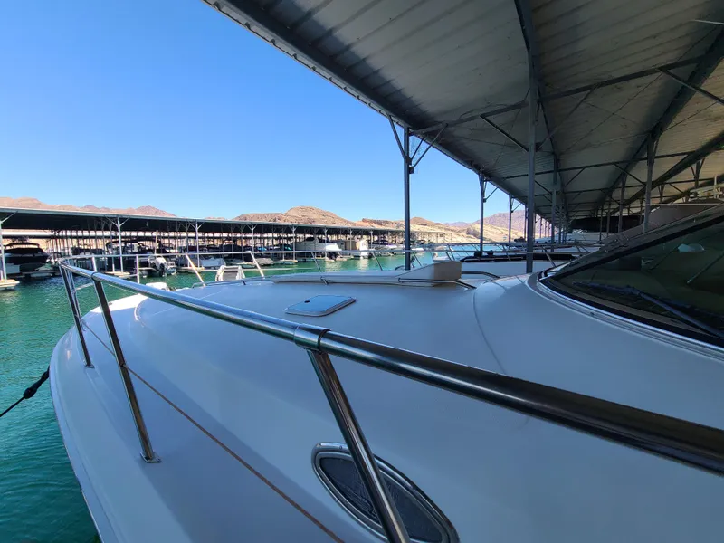 Slide: The Image of 1998 Sea Ray 400 Sundancer yacht docked in a marina under a covered structure. - 28