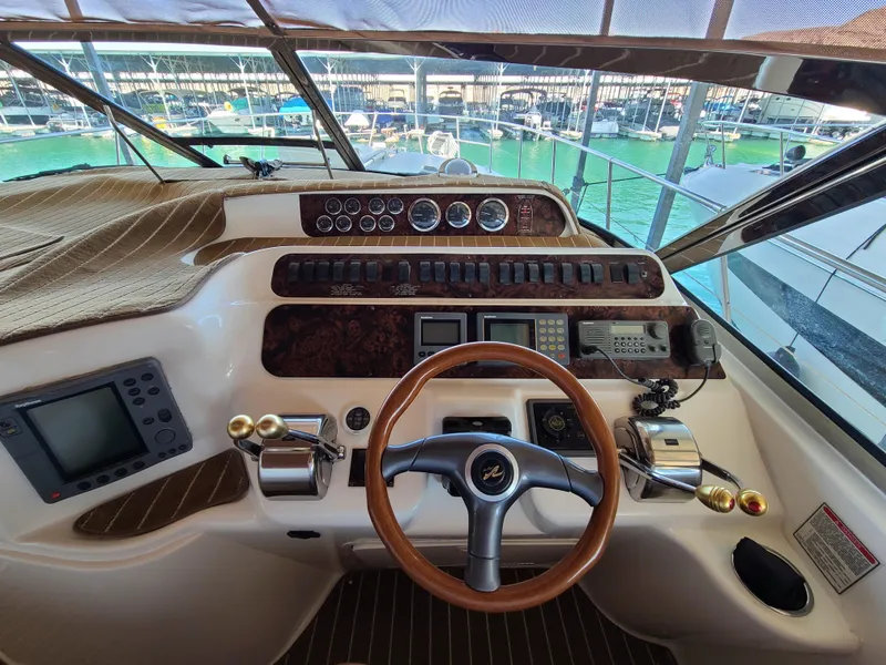 Slide: The Image of Cockpit of 1998 Sea Ray 400 Sundancer with steering wheel and control panels. - 4