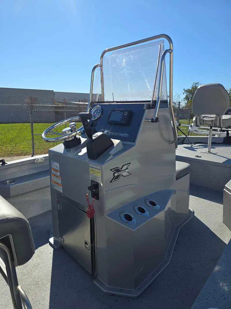 Slide: The Image of 2022 Xpress H20B boat console with steering wheel and controls, outdoors. - 11