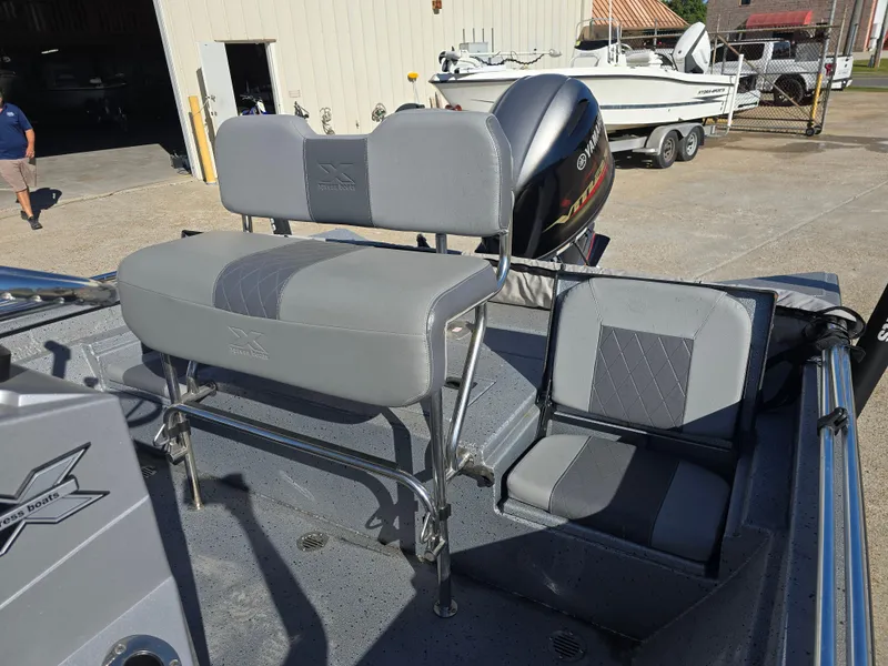 Slide: The Image of 2022 Xpress H20B boat interior with gray seating and outboard motor. - 12