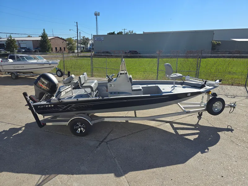 Slide: The Image of 2022 Xpress H20B boat on trailer, parked outdoors in a fenced area. - 3