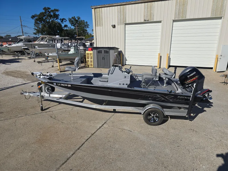 Slide: The Image of 2022 Xpress H20B boat on trailer, parked outside a building. - 7