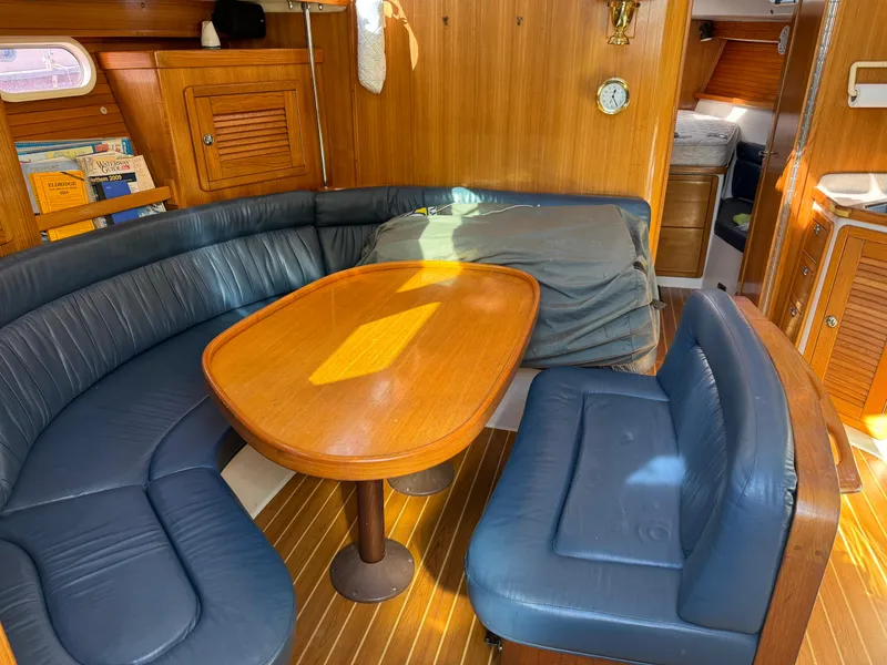 Slide: The Image of Interior of 2004 Catalina 42 MkII sailboat with blue seating and wooden table. - 35