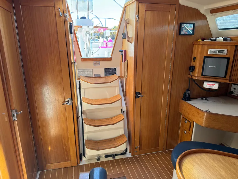 Slide: The Image of Interior of 2004 Catalina 42 MkII sailboat with wooden cabinetry and steps. - 42
