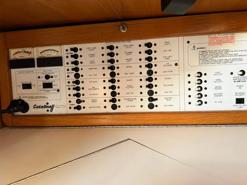 Slide: The Image of Electrical control panel of 2004 Catalina 42 MkII sailboat, featuring various switches and gauges. - 44
