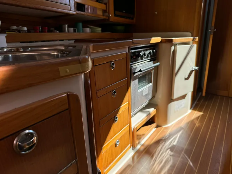 Slide: The Image of 2004 Catalina 42 MkII yacht kitchen with wooden cabinets and modern appliances. - 49