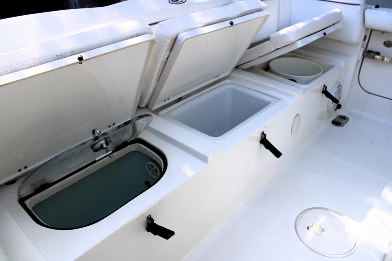 Slide: The Image of 2018 Sea Hunt Ultra 255 SE boat storage compartments open on deck. - 16