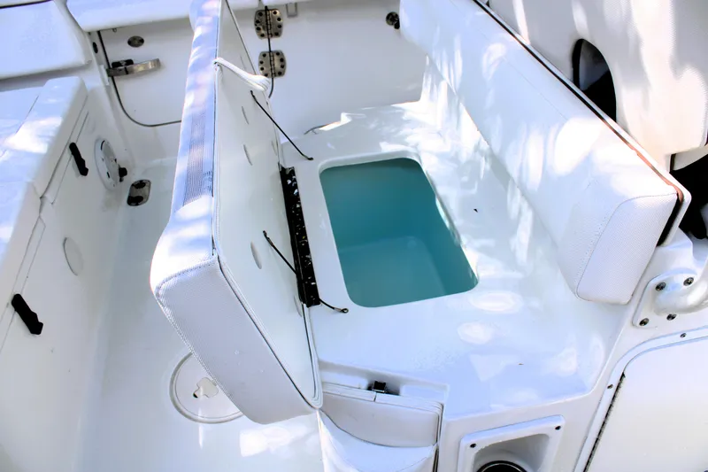 Slide: The Image of 2018 Sea Hunt Ultra 255 SE boat seating with storage compartment open. - 20