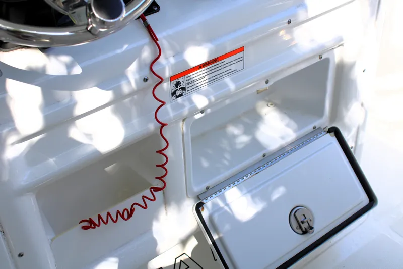 Slide: The Image of 2018 Sea Hunt Ultra 255 SE boat console with red safety cord and storage compartment. - 28