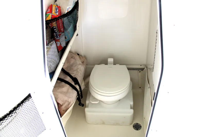 Slide: The Image of 2018 Sea Hunt Ultra 255 SE boat interior with toilet and storage compartments. - 29
