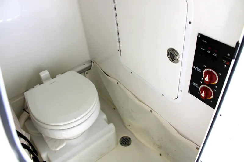 Slide: The Image of 2018 Sea Hunt Ultra 255 SE boat interior with toilet and control panel. - 30