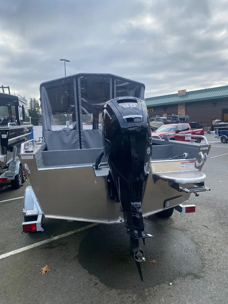 Slide: The Image of 2025 Spartan 18 Areus boat with outboard motor in parking lot. - 2