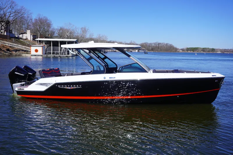 Slide: The Image of 2025 Monterey Elite 30 OB boat on a serene lake under clear blue skies. - 1