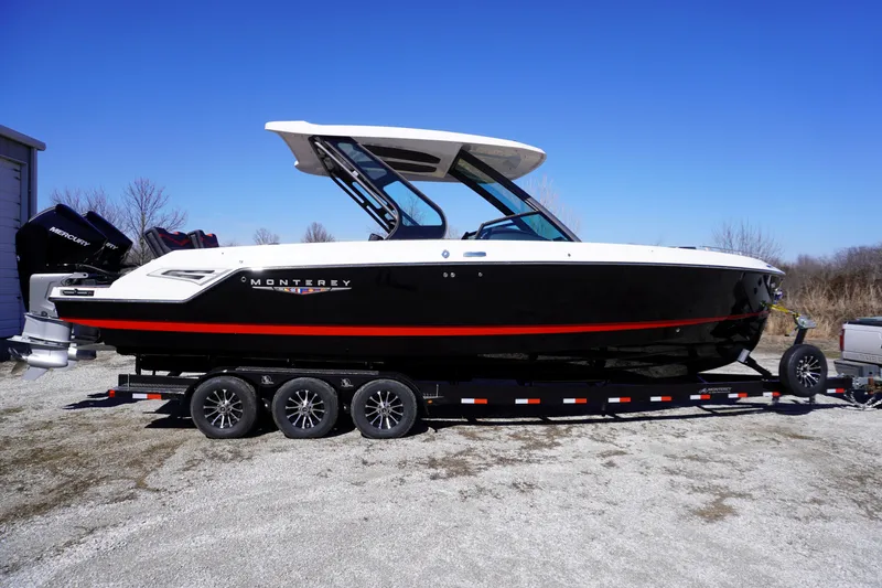 Slide: The Image of 2025 Monterey Elite 30 OB boat on trailer, sleek black design with red accents. - 4