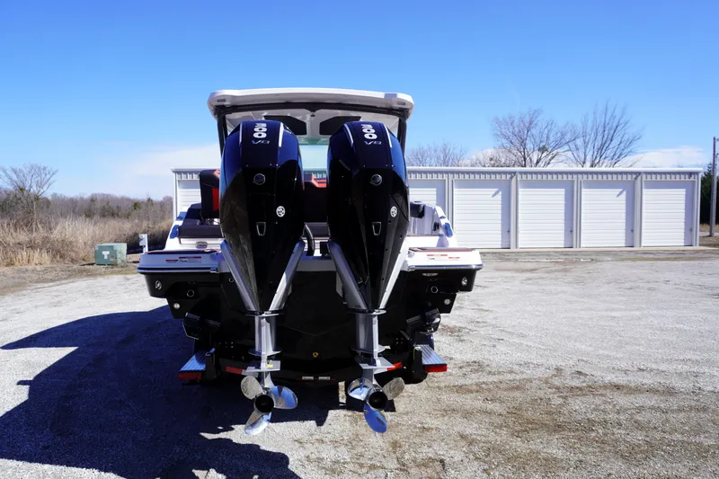 Slide: The Image of 2025 Monterey Elite 30 OB boat with dual outboard engines, parked outdoors. - 9