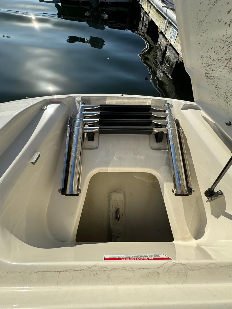 Slide: The Image of 2008 Sea Ray 230 Sundeck boat ladder and storage compartment by the water. - 11
