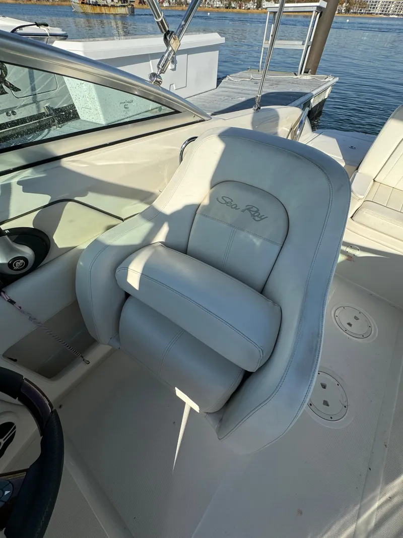 Slide: The Image of 2008 Sea Ray 230 Sundeck boat interior with white seating and steering wheel. - 12