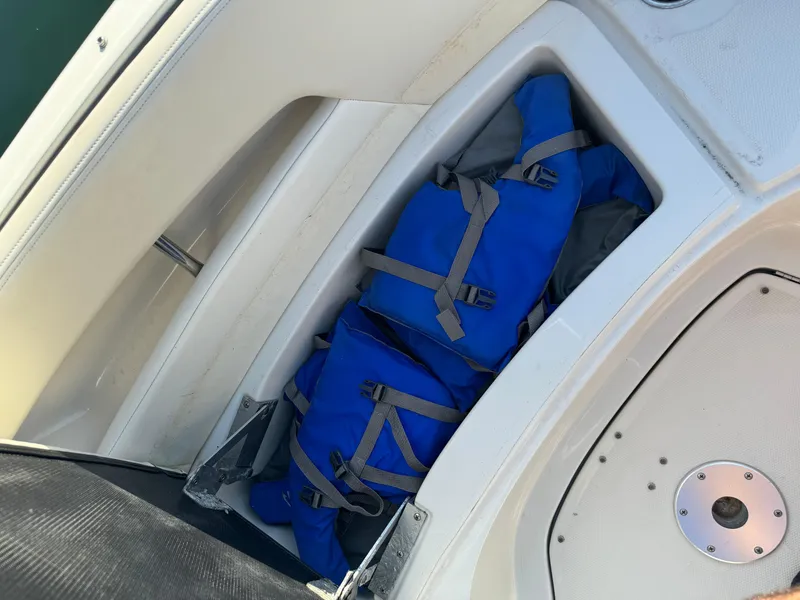 Slide: The Image of Blue life jackets stored on a 2008 Sea Ray 230 Sundeck boat. - 13