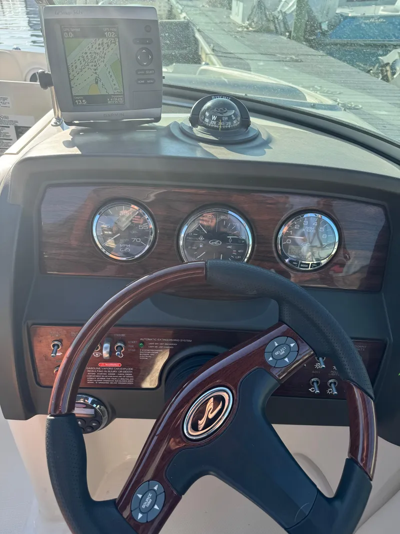 Slide: The Image of Dashboard of 2008 Sea Ray 230 Sundeck with steering wheel and navigation instruments. - 17