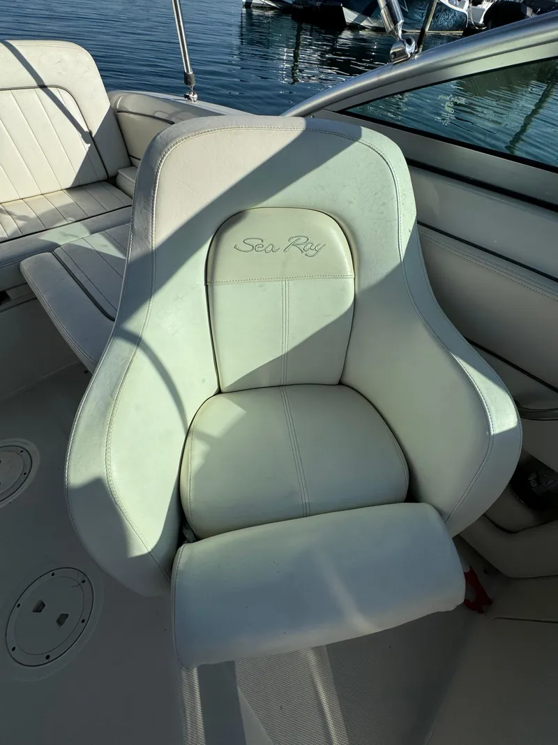 Slide: The Image of 2008 Sea Ray 230 Sundeck boat seat, white leather, on calm water. - 2